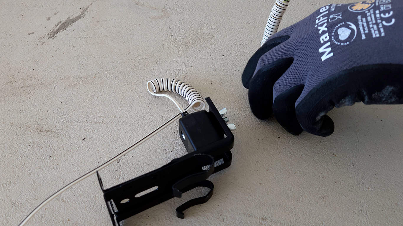 A Firstline Garage Door Repair technician is starting the calibration of the safety sensors.
