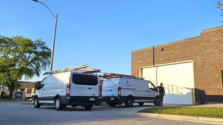 Our technician and both of our crew members are standing next to the newly installed commercial garage door.
